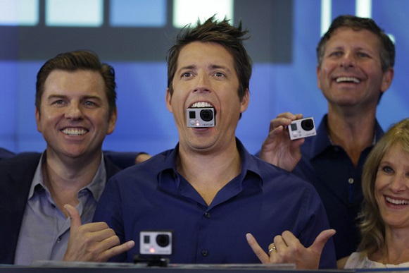GoPro's CEO Nick Woodman holds a GoPro camera in his mouth as he celebrates his company's IPO at the Nasdaq MarketSite in New York, Thursday, June 26, 2014. GoPro, the maker of wearable sports cameras, loved by mountain climbers, divers, surfers and other extreme sports fans, said late Wednesday it sold 17.8 million shares at $24 each in its initial public offering of stock. (AP Photo/Seth Wenig)
